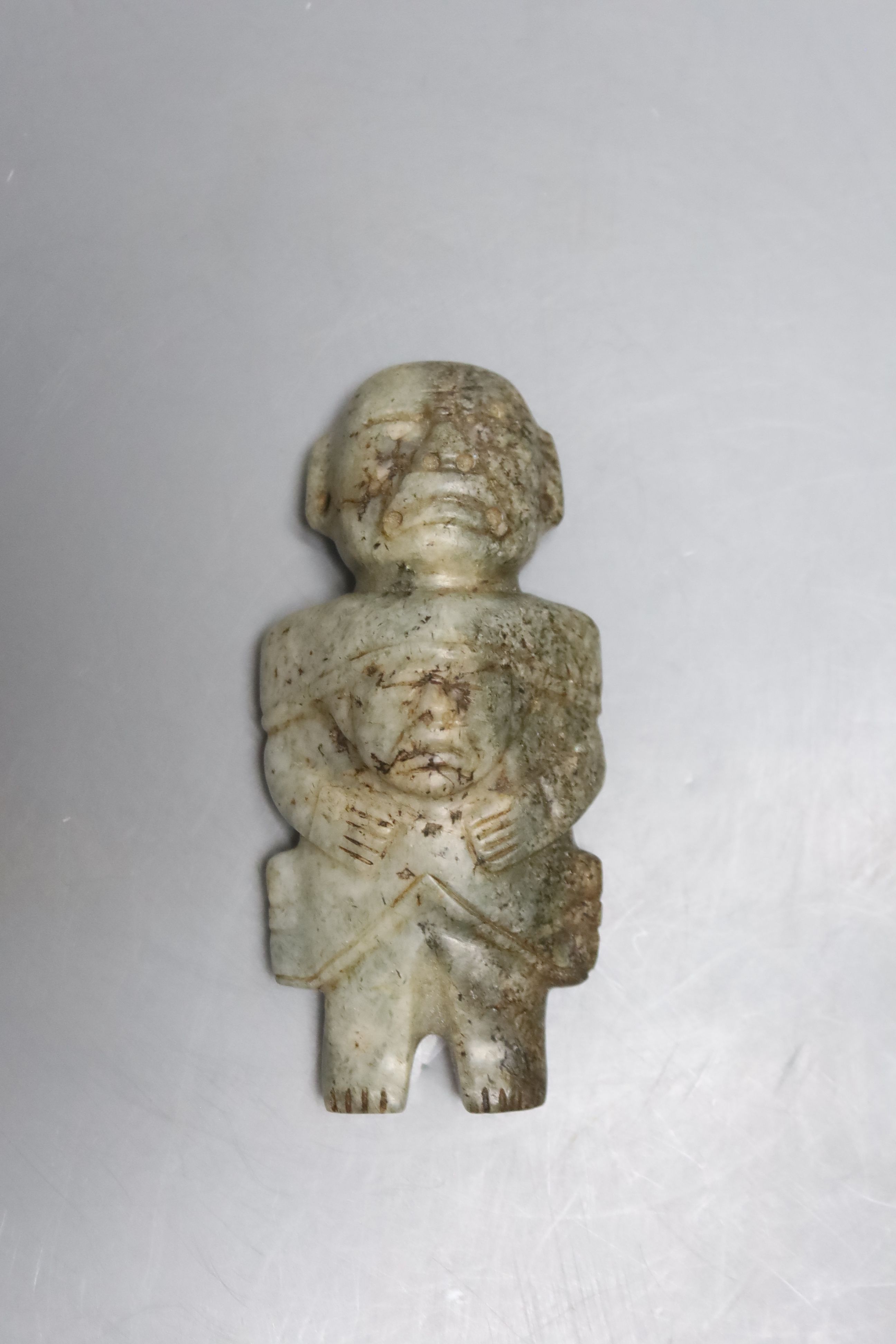 A Meso American jadeite group of a parent carrying a child, possibly Maya Culture, 200-800AD